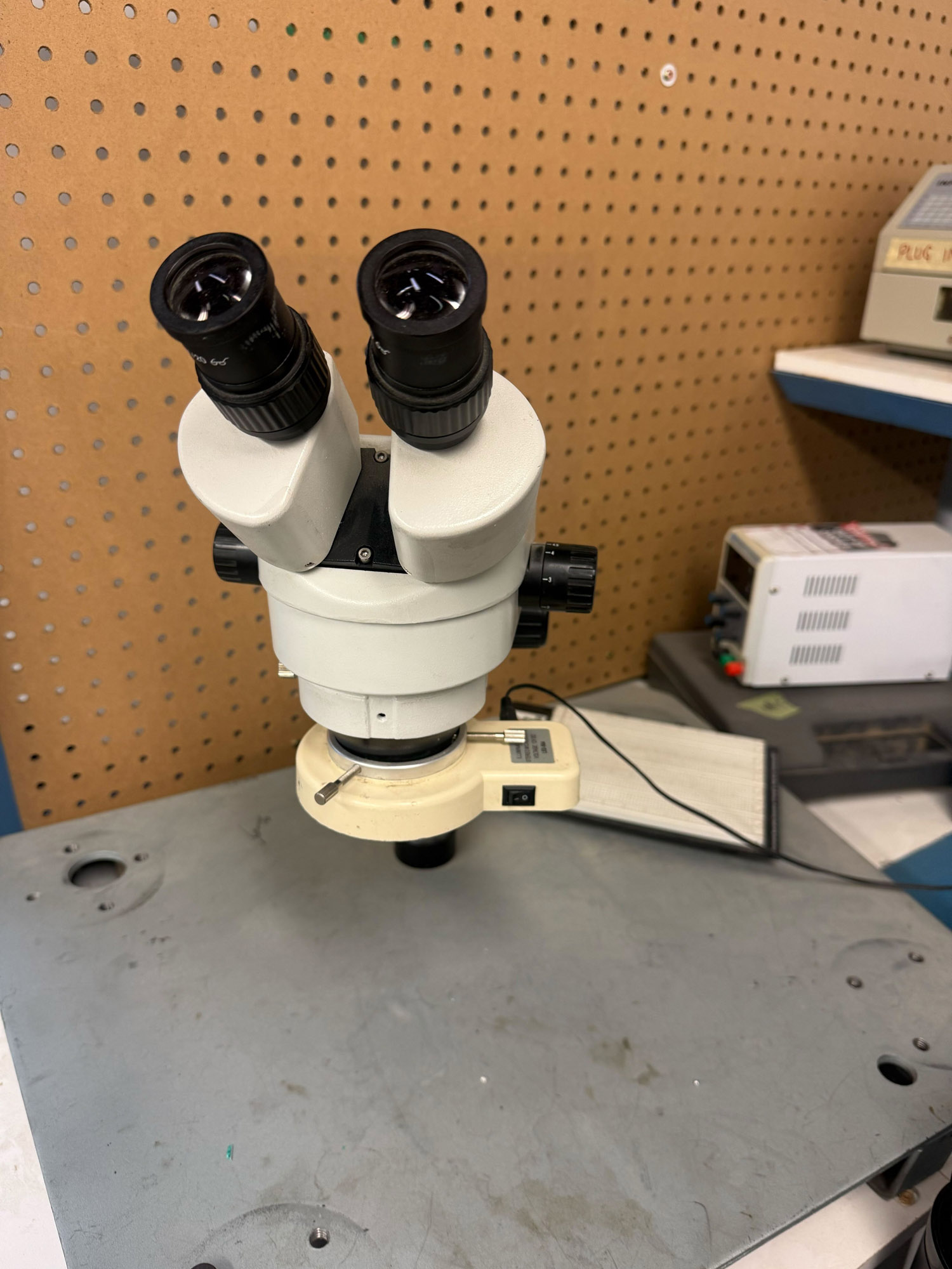 A binocular microscope with a light attcahed near the bottom, on an arm with a relatively large working distance